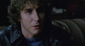 Movie still from “Withnail & I” (1987), directed by Bruce Robinson – A person wearing a leather jacket; Close Up shot, Over the shoulder angle