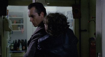 Movie still from “Withnail & I” (1987), directed by Bruce Robinson – A man and a woman are standing together in a room; Close Up shot, Over the shoulder angle