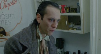 Movie still from “Withnail & I” (1987), directed by Bruce Robinson – A man with long black hair wearing a jacket and a tie; Close Up shot, Low angle