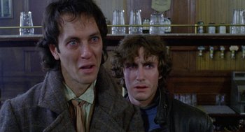 Movie still from “Withnail & I” (1987), directed by Bruce Robinson – Two men standing next to each other in front of a counter; Close Up shot, Low angle