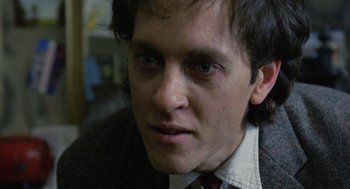Movie still from “Withnail & I” (1987), directed by Bruce Robinson – A person wearing a suit and tie; Close Up shot, Over the shoulder angle
