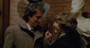Movie still from “Withnail & I” (1987), directed by Bruce Robinson – A man holding a key to another man's face; Close Up shot, High angle