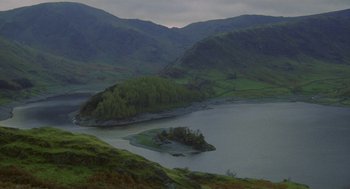 Movie still from “Withnail & I” (1987), directed by Bruce Robinson – A small island in the middle of a lake surrounded by mountains; Extreme Wide shot, High angle