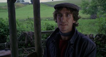Movie still from “Withnail & I” (1987), directed by Bruce Robinson – A young man wearing a hat and a jacket; Close Up shot, Over the shoulder angle