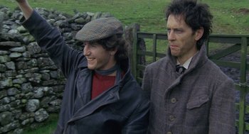 Movie still from “Withnail & I” (1987), directed by Bruce Robinson – Two men standing next to each other on a field; Medium shot, High angle