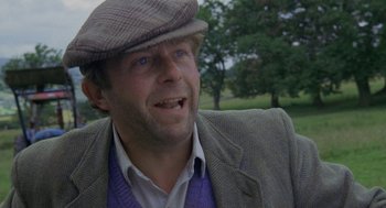 Movie still from “Withnail & I” (1987), directed by Bruce Robinson – A person wearing a hat and a jacket; Close Up shot, Low angle