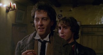 Movie still from “Withnail & I” (1987), directed by Bruce Robinson – Two young men standing next to each other; Close Up shot, Over the shoulder angle