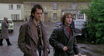 Movie still from “Withnail & I” (1987), directed by Bruce Robinson – Two men are walking down the street together; Medium shot, Over the shoulder angle