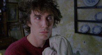 Movie still from “Withnail & I” (1987), directed by Bruce Robinson – A young man holding a towel in a room; Close Up shot, Low angle