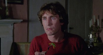 Movie still from “Withnail & I” (1987), directed by Bruce Robinson – A young man holding a plant in his hand; Close Up shot, Low angle