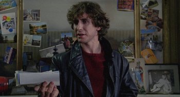Movie still from “Withnail & I” (1987), directed by Bruce Robinson – A young man in a leather jacket clapping his hands; Close Up shot, Over the shoulder angle