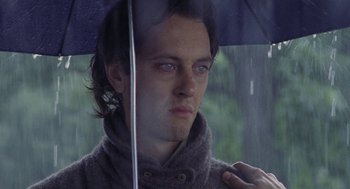 Movie still from “Withnail & I” (1987), directed by Bruce Robinson – A person holding an open umbrella; Close Up shot, Low angle