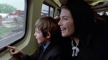 Movie still from “Witness” (1985), directed by Peter Weir – A woman sitting next to a young boy on a train; Close Up shot, Over the shoulder angle