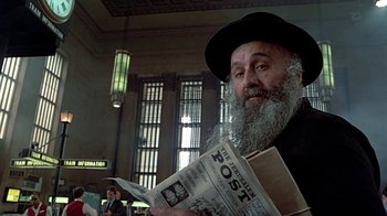 Movie still from “Witness” (1985), directed by Peter Weir – An old man with a beard and a hat is reading a newspaper; Close Up shot, Low angle