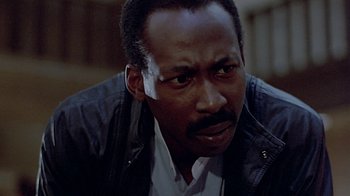 Movie still from “Witness” (1985), directed by Peter Weir – A person wearing a leather jacket; Close Up shot, Low angle