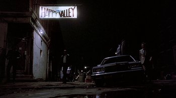 Movie still from “Witness” (1985), directed by Peter Weir – A car parked on the side of the road at night; Wide shot, Low angle