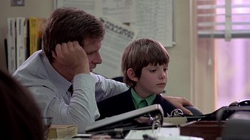Movie still from “Witness” (1985), directed by Peter Weir – A man and a boy sitting at a desk; Close Up shot, Over the shoulder angle