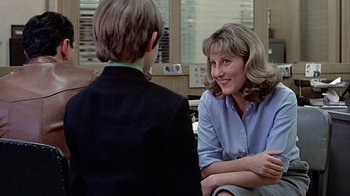Movie still from “Witness” (1985), directed by Peter Weir – A woman sitting next to a young boy in a room; Medium shot, Over the shoulder angle