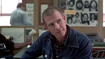 Movie still from “Witness” (1985), directed by Peter Weir – A person sitting in a room; Close Up shot, Over the shoulder angle