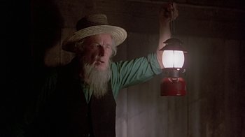 Movie still from “Witness” (1985), directed by Peter Weir – An old man with a beard holding a lantern; Close Up shot, Low angle
