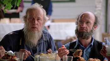 Movie still from “Witness” (1985), directed by Peter Weir – Two men sitting at a table eating food; Close Up shot, Low angle