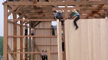 Movie still from “Witness” (1985), directed by Peter Weir – A group of men working on a wooden structure; Extreme Wide shot, Low angle