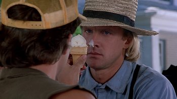 Movie still from “Witness” (1985), directed by Peter Weir – A man in a straw hat is eating a piece of ice cream; Close Up shot, Over the shoulder angle