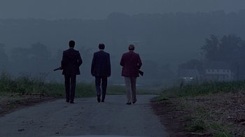 Movie still from “Witness” (1985), directed by Peter Weir – A group of men walking down a road at night; Extreme Wide shot, Low angle