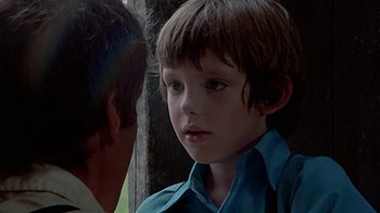 Movie still from “Witness” (1985), directed by Peter Weir – A young boy is looking into the distance; Close Up shot, Over the shoulder angle