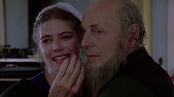 Movie still from “Witness” (1985), directed by Peter Weir – An older man and a younger woman smiling for the camera; Close Up shot, Over the shoulder angle