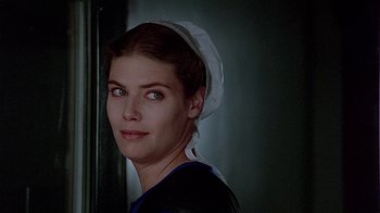 Movie still from “Witness” (1985), directed by Peter Weir – A woman wearing a nurse's hat and a black shirt; Close Up shot, Low angle