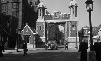 Movie still from “Witness for the Prosecution” (1957), directed by Billy Wilder – A black and white photo of a gate with a car in front of it; Extreme Wide shot, High angle