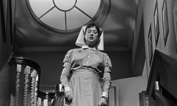 Movie still from “Witness for the Prosecution” (1957), directed by Billy Wilder – An old photo of a woman wearing a nurse's hat; Medium shot, Low angle