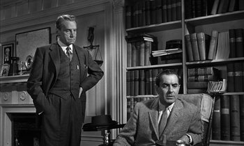 Movie still from “Witness for the Prosecution” (1957), directed by Billy Wilder – Two men in suits and ties in a room with a bookshelf; Medium shot, Low angle