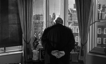 Movie still from “Witness for the Prosecution” (1957), directed by Billy Wilder – An older man standing in front of a window looking outside; Medium shot, Over the shoulder angle