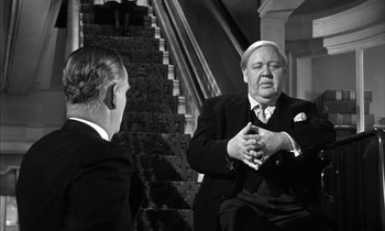 Movie still from “Witness for the Prosecution” (1957), directed by Billy Wilder – Two men in suits are sitting on the stairs; Medium shot, Over the shoulder angle