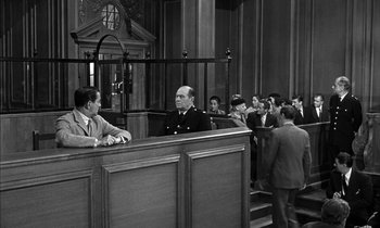 Movie still from “Witness for the Prosecution” (1957), directed by Billy Wilder – An old photo of a man in a court room; Wide shot, High angle