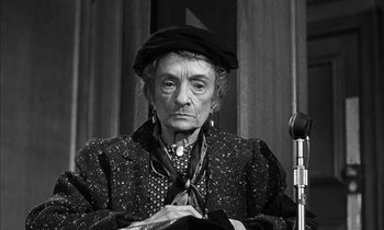 Movie still from “Witness for the Prosecution” (1957), directed by Billy Wilder – An older woman wearing a hat and a tie; Close Up shot, High angle