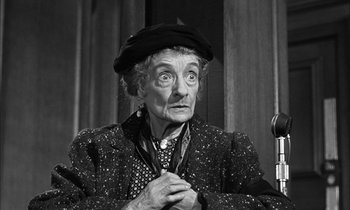 Movie still from “Witness for the Prosecution” (1957), directed by Billy Wilder – An older woman wearing a hat and a jacket; Close Up shot, High angle