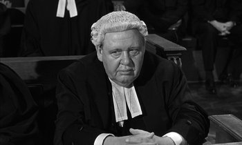 Movie still from “Witness for the Prosecution” (1957), directed by Billy Wilder – An older man wearing a judge's wig and wig; Close Up shot, High angle