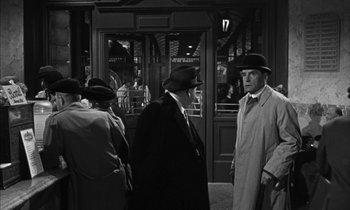 Movie still from “Witness for the Prosecution” (1957), directed by Billy Wilder – A black and white photo of two men in suits and hats; Medium shot, Over the shoulder angle