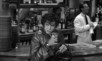 Movie still from “Witness for the Prosecution” (1957), directed by Billy Wilder – A woman sitting at a bar holding a drink; Medium shot, High angle
