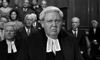 Movie still from “Witness for the Prosecution” (1957), directed by Billy Wilder – An old photo of a man in a judge's wig; Medium shot, Low angle