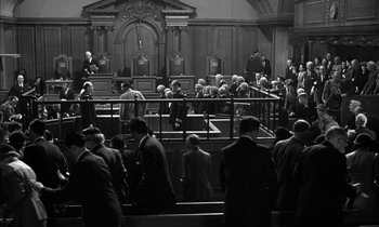 Movie still from “Witness for the Prosecution” (1957), directed by Billy Wilder – A group of people standing in front of a court room; Wide shot, High angle