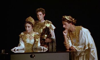 Movie still from “Wittgenstein” (1993), directed by Derek Jarman – A group of people dressed up in ancient roman clothing; Medium shot, High angle
