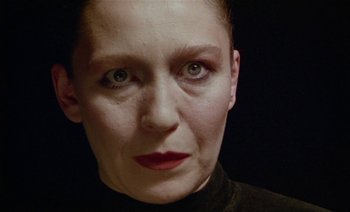 Movie still from “Wittgenstein” (1993), directed by Derek Jarman – A person wearing a black shirt; Close Up shot, Low angle
