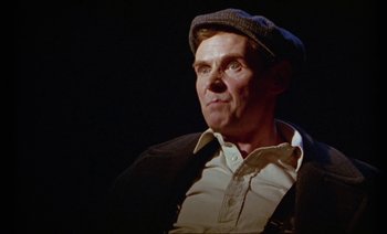 Movie still from “Wittgenstein” (1993), directed by Derek Jarman – An older man wearing a hat and a jacket; Close Up shot, Low angle