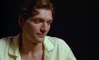 Movie still from “Wittgenstein” (1993), directed by Derek Jarman – A person wearing a white shirt; Close Up shot, High angle