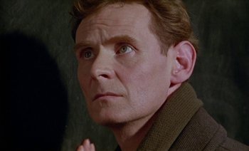 Movie still from “Wittgenstein” (1993), directed by Derek Jarman – A person wearing a jacket; Close Up shot, Low angle