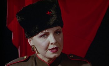 Movie still from “Wittgenstein” (1993), directed by Derek Jarman – A person wearing a hat; Close Up shot, Low angle